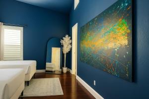 une chambre bleue avec un lit et un tableau au mur dans l'établissement Huge Ceilings Pool Piano ART, à Dallas