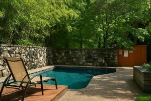une chaise assise à côté d'une piscine dans l'établissement Huge Ceilings Pool Piano ART, à Dallas
