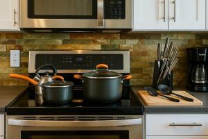 deux casseroles sur une cuisinière dans une cuisine dans l'établissement Huge Ceilings Pool Piano ART, à Dallas