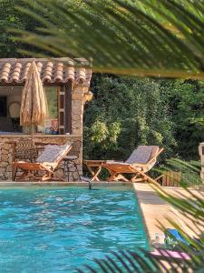 a swimming pool with two chairs and a house at VillaCarros - Studios in Sea & Mountain Villa near Nice with Idyllic View in Carros