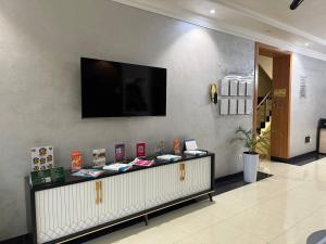 een kamer met een televisie aan een muur en een aanrecht bij Hotel Moon in Yakkasaray