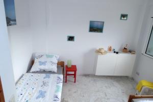 a bedroom with a bed and a red chair at Finikounda in Finikounta
