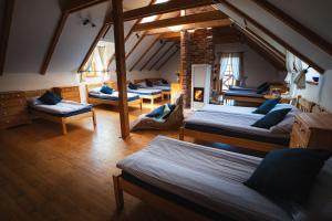 um quarto no sótão com quatro camas e um quarto com cadeiras em Starý Svět em Wotitz