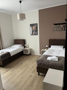 Dos camas en una habitación con suelo de madera. en Wilczy Sen, en Ciechanów 8 fotos más