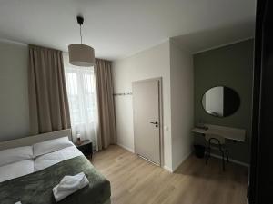 Un dormitorio con una cama, un escritorio y un espejo. en Wilczy Sen, en Ciechanów