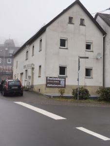 een zwarte auto geparkeerd voor een wit gebouw bij Ferienhaus in Berenbach in Berenbach