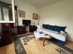 a living room with a blue couch and a table at Fenix Mostar in Mostar