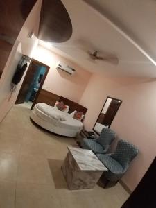 ein Wohnzimmer mit einem Bett und 2 Stühlen in der Unterkunft Hotel Moon Stone in Zirakpur