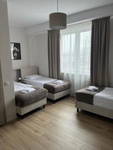 Un dormitorio con dos camas y una ventana. en Wilczy Sen, en Ciechanów