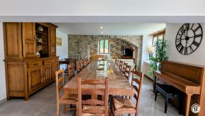 ein Esszimmer mit einem langen Tisch und einem Klavier in der Unterkunft Ô Coeur des Liens in Saint-Seine-lʼAbbaye
