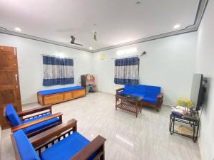 sala de estar con sillas azules y TV de pantalla plana en Casa 2bhk home, en Parxem