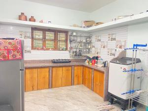 Una cocina con gabinetes de madera y un refrigerador blanco. en Casa 2bhk home, en Parxem
