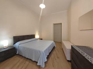 een slaapkamer met een bed en 2 lampen en een deur bij Casa Di Nonna in Cuglieri