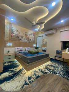 ein Schlafzimmer mit einem großen Bett mit einem Gemälde an der Decke in der Unterkunft SAJ motel 02 in Belgaum