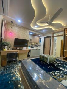 ein Wohnzimmer mit einem Deckenventilator und einem Schreibtisch in der Unterkunft SAJ motel 02 in Belgaum + 2 Fotos