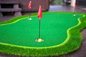 a green golf course with a red flag on it at 5 Bedroom - Four En-Suite & Bunk Loft w/half bath in Stephens Gap