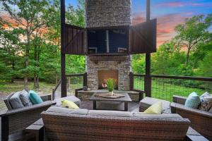 a patio with couches and a stone fireplace at 5 Bedroom - Four En-Suite & Bunk Loft w/half bath in Stephens Gap