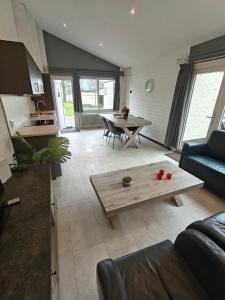 ein Wohnzimmer mit Sofa und Tisch in der Unterkunft Bungalow 21 - Nelderhut in Simpelveld