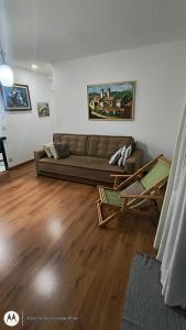 Una sala de estar con un sofá y suelo de madera. en Apartamento Aconchegante-1105, en Itatiba