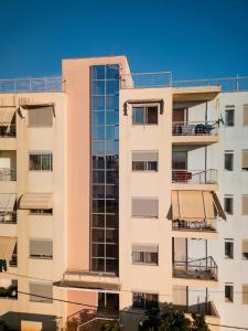 Un edificio alto y blanco con muchas ventanas. en Agnanti Apartment, en Agrinio