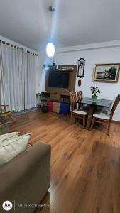 Una sala de estar con una mesa y un televisor. en Apartamento Aconchegante-1105, en Itatiba 33 fotos más