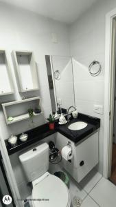 Un baño con un inodoro blanco y un lavabo. en Apartamento Aconchegante-1105, en Itatiba