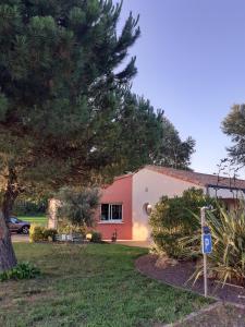 ein Haus mit einem Baum davor in der Unterkunft Chambre d'hôtes - Acrifolia in Aigrefeuille-sur-Maine