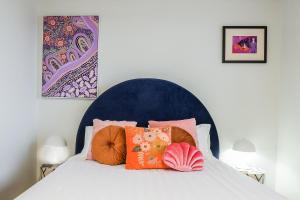 a bed with a blue headboard with pillows on it at Cake By The Ocean in Seventeen Seventy