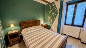 ein kleines Schlafzimmer mit einem Bett und einem Fenster in der Unterkunft La forge in Saint-Julien-le-Petit