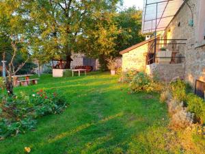 einen Hof mit einem Steingebäude und einem Baum in der Unterkunft La forge in Saint-Julien-le-Petit + 6 Fotos