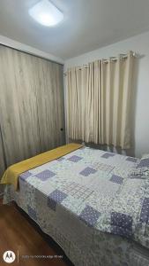 a bedroom with a bed with a quilt on it at Apartamento Aconchegante-1105 in Itatiba