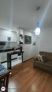 Una sala de estar con un sofá y una cocina. en Apartamento Aconchegante-1105, en Itatiba