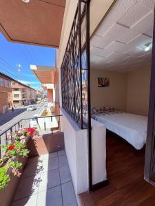een balkon met een bed aan de zijkant van een gebouw bij Aquisito Nomas Es in Cuenca