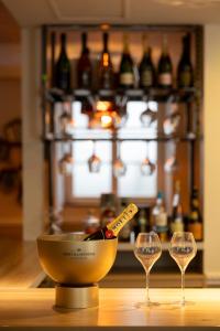 a bottle of wine in a bowl and two glasses at Hotel Jean Moët in Épernay