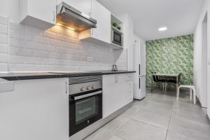 Una cocina con gabinetes blancos y un horno de estufa. en Apartamento familiar privado, en Santa Cruz de Tenerife
