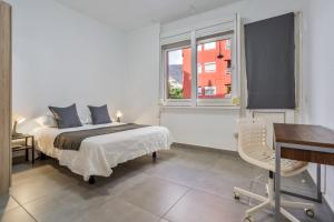 Un dormitorio con una cama y un escritorio y una ventana. en Apartamento familiar privado, en Santa Cruz de Tenerife