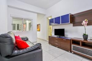 Una sala de estar con un sofá de cuero y un televisor. en Apartamento familiar privado, en Santa Cruz de Tenerife