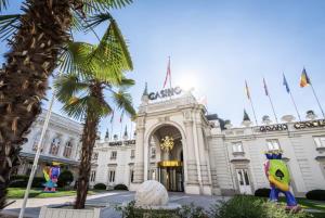 エクスレバンにあるGrand T2 lumineux et cosy - 1min Termes Marliozの前にヤシの木がある建物