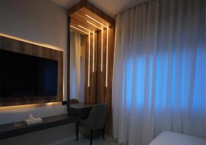 a hotel room with a television and a desk with a chair at Al Jawhara Hotel Suites in Amman +6 photos
