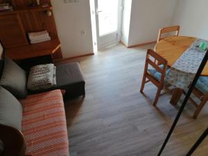 a living room with a couch and a table and chair at Apartman Ustrine in Ustrine