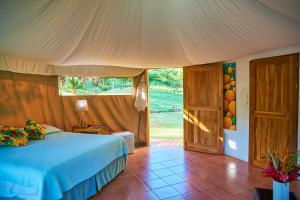 a bedroom with a bed and a large window at Manoas in Uvita