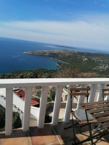 a balcony with a chair and a view of the ocean at Apartman Ustrine in Ustrine