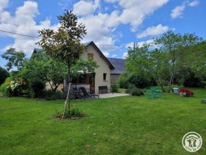 una casa con un cortile con un albero di Le fournil a Marcillac-la-Croisille