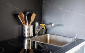 eine Küchentheke mit einer Spüle und Küchenutensilien in der Unterkunft luxueux a coté de la Mer in Nizza