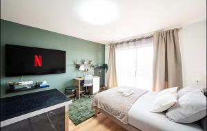 ein Schlafzimmer mit einem Bett und einem Fernseher an der Wand in der Unterkunft luxueux a coté de la Mer in Nizza
