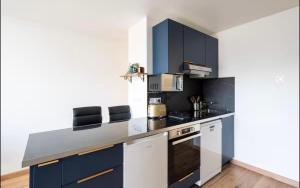 eine Küche mit blauen Schränken und einer Arbeitsplatte in der Unterkunft luxueux a coté de la Mer in Nizza