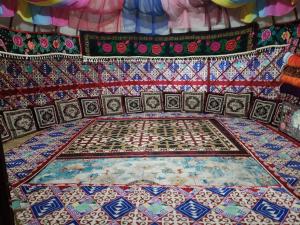 een kamer met een kleurrijk tapijt op de vloer bij Maksyt Ata Hostel in Kalday