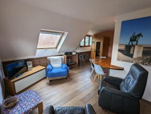 a living room with a couch and a tv and a table at Oostduinkerke Apartments in Oostduinkerke