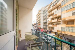 un balcon avec des chaises et des tables et un bâtiment dans l'établissement GuestReady - Modern Comfort in Almada, à Almada