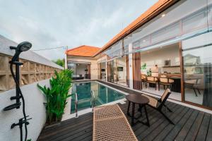 a balcony with a pool and a table and chairs at Villa Gadang in Kerobokan +18 photos